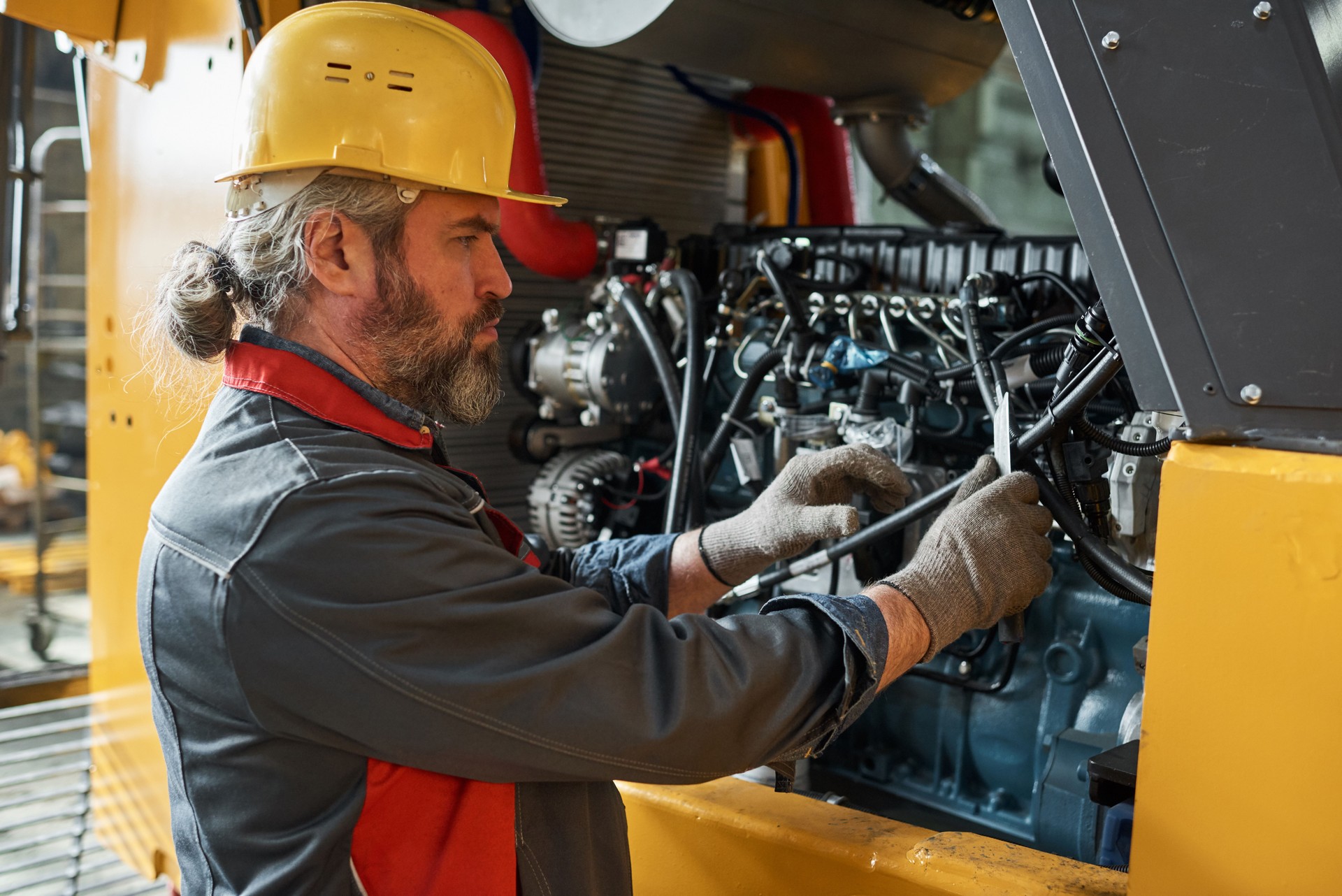 Mechanic repairing the machine in factory